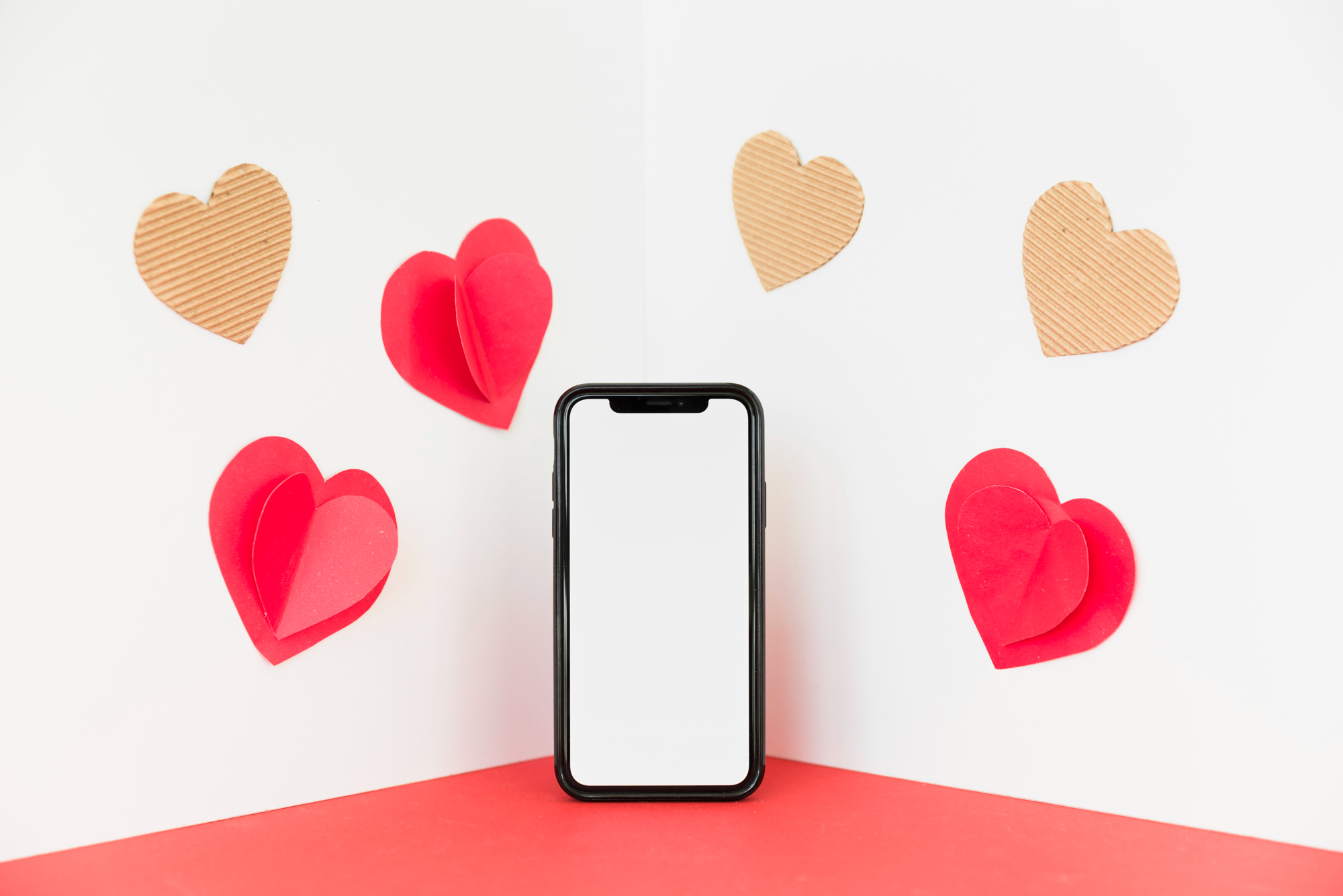 Smartphone surrounded by heart-shaped cutouts. This is a blog banner for a blog talking about app retargeting strategies for valentine's day.